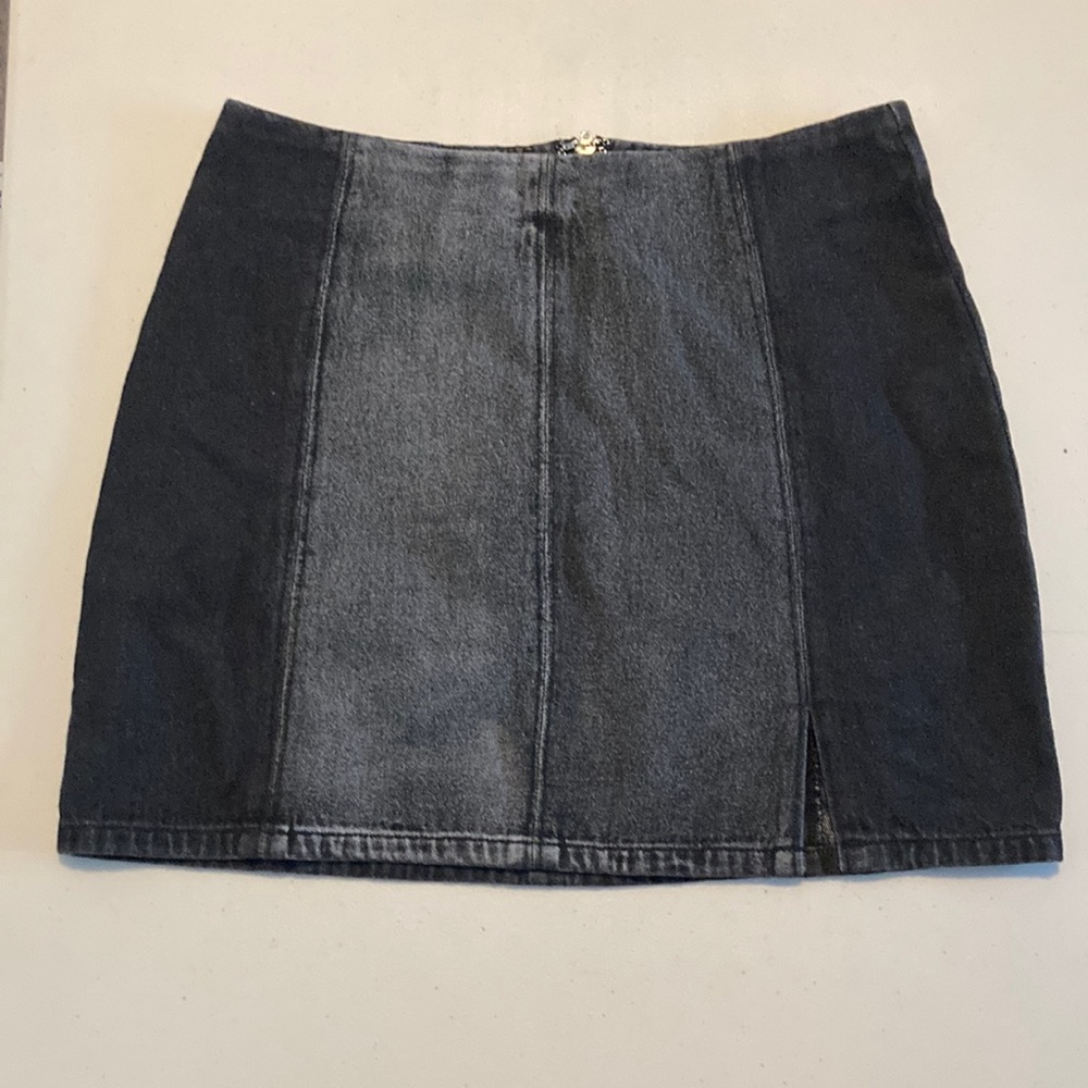 NWOT two-tone black denim mini skirt with front slit. Size M